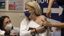 Žena dostáva štvrtú dávku vakcíny proti ochoreniu COVID-19 od spoločnosti Pfizer-BioNTech počas vakcinácie v izraelskom meste Ramat Gan.