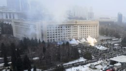 Dym stúpa z budovy radnice počas protestu v meste Alma-Ata.