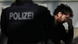 Na snímke policajt v nemeckej policajnej uniforme a muž držiaci sa za hlavu