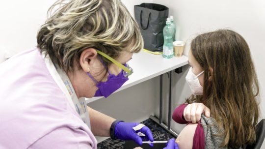 Lekárka očkuje dievča vakcínou proti ochoreniu COVID-19 v Bratislave.