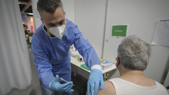Muž dostáva vakcínu počas očkovania proti ochoreniu COVID-19.
