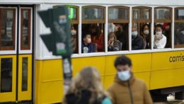 cestujúci s ochrannými rúškami na tvári proti šíreniu ochorenia COVID-19 sedia v električke v Lisabone