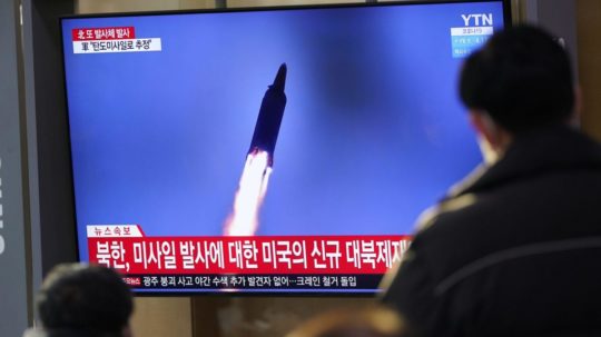 Ľudia sledujú na televíznej obrazovke vypálenie rakety Severnou Kóreou počas vysielania správ.