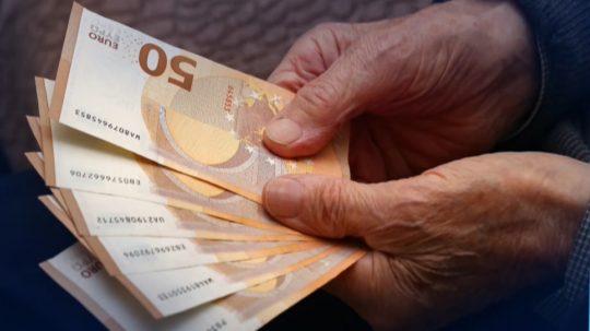 Senior drží eurové bankovky.