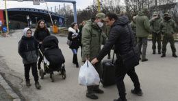 Utečenci z Ukrajiny prechádzajú cez hraničný priechod vo Vyšnom Nemeckom, uprostred im pomáha colník.