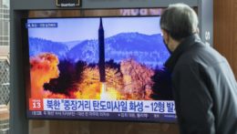 Muž pozerá v televízore najnovší raketový test Severnej Kórey.