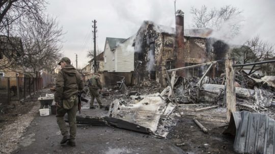 Ukrajinskí vojaci kráčajú popri úlomkoch zostreleného lietadla videného v Kyjeve.