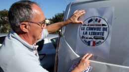 Muž lepí plagát s nápisom "Konvoj slobody" na dodávku pred odchodom do Paríža vo francúzskom meste Bayonne.