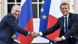 Na archívnej snímke z 19. augusta 2019 francúzsky prezident Emmanuel Macron (vpravo) a ruský prezident Vladimir Putin si podávajú ruky.