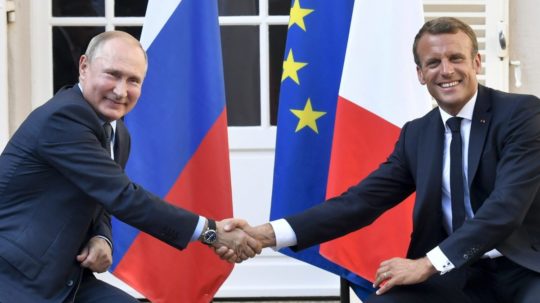 Na archívnej snímke z 19. augusta 2019 francúzsky prezident Emmanuel Macron (vpravo) a ruský prezident Vladimir Putin si podávajú ruky.