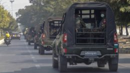 konvoj vojenských vozidiel hliadkuje na ulici v majnamrskom Mandalay.