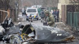 Vojak ukrajinskej armády kontroluje úlomky zostreleného lietadla v Kyjeve na Ukrajine.