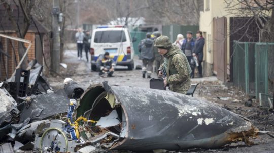 Vojak ukrajinskej armády kontroluje úlomky zostreleného lietadla v Kyjeve na Ukrajine.
