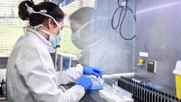 Zamestnankyňa vo virologickom laboratóriu skúma vzorky testov na nový koronavírus.