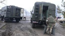 Ukrajinskí vojaci nakladajú materiál v zničenom ukrajinskom vojenskom zariadení pri Mariupole.