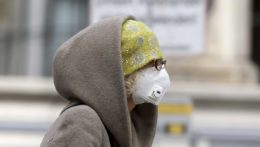 Žena s respirátom na tvári kráča ulicou vo Viedni.