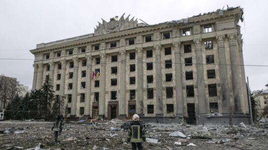 Hasič sa pozerá na zničenú radnicu v Charkove.