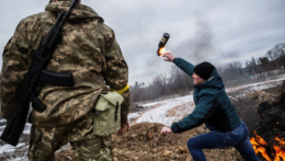 Muž hádže Molotovov koktejl pri bojoch o mesto Cherson na Ukrajine.
