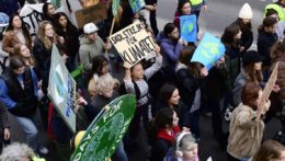 Aktivistka Greta Thunbergová (uprostred) drží transparent s nápisom "Školský štrajk pre klímu" počas štrajku za klímu a sociálnu spravodlivosť hnutia Piatky pre budúcnosť v Štokholme.