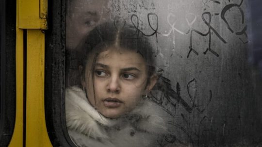 Dieťa pozerá cez okno evakuačného autobusu z mesta Irpiň.