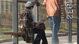 Na ilustračnej snímke sedí dôchodkyňa na autobusovej zastávke.