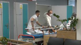 Lekári v nemocnici tlačia pacienta na lôžku.