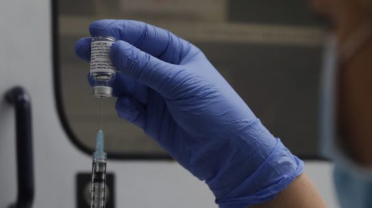 Vedec naťahuje injekčnou striekačkou z ampulky vakcínu proti ochoreniu COVID-19 od americkej farmaceutickej spoločnosti Novavax.