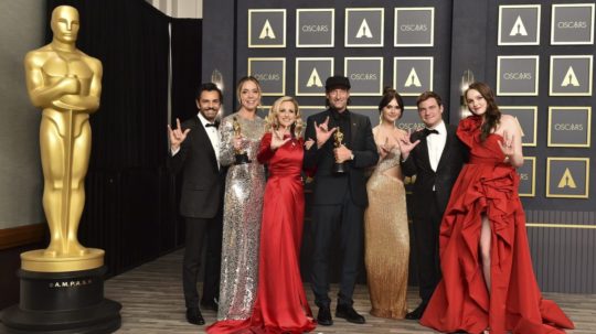 Zľava Eugenio Derbez, Sian Hederová, Marlee Matlinová, Troy Kotsur, Emilia Jonesová, Daniel Durant a Amy Forsythová pózujú so soškou Oscara v kategórii najlepší film za snímku CODA (V rytme srdca).