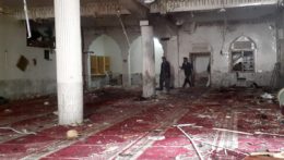 Dobrovoľníci skúmajú miesto výbuchu v šiitskej mešite v Pakistane.