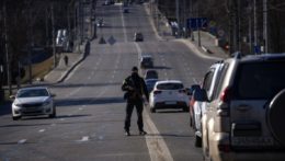 Policajt hliadkuje na ceste vedúcej do centra Kyjeva.