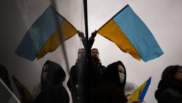Muž drží ukrajinskú vlajku počas protestu.