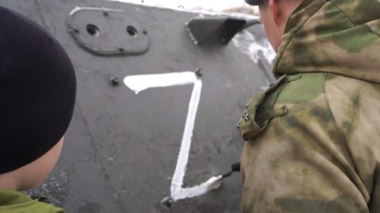 Na snímke ruskí vojaci maľujú písmeno Z na tank.