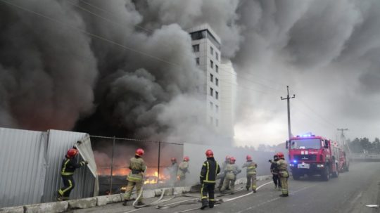 Na archívnej snímke sa hasiči snažia uhasiť oheň po ostreľovaní v Kyjeve.