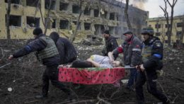 Pohotovostné zložky odnášajú zranenú tehotnú ženu z mariupolskej nemocnice, ktorú zbombardovali Rusi.