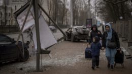ženy a chlapec kráčajú smerom k vlakovej stanici, aby mohli opustiť Kyjev