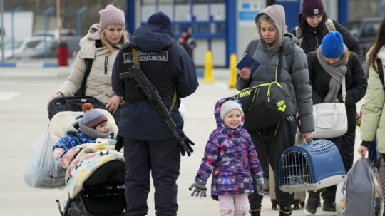 Príslušník moldavskej pohraničnej stráže kontroluje dokumenty utečencov utekajúcich pred vojenským konfliktom na Ukrajine.