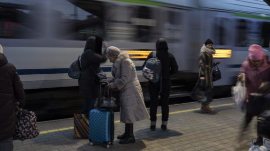 Ukrajinskí utečenci utekajúci pred vojenským konfliktom na Ukrajine čakajú na vlak.