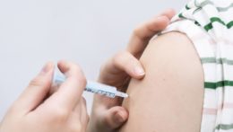 Zdravotníčka pichá žene vakcínu proti koronavírusu.