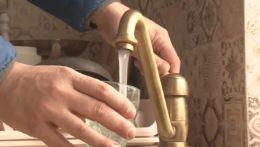 muž si do pohára napúšťa vodu z vodovodu