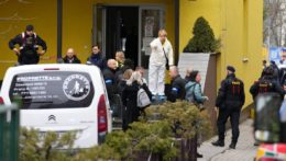 Českí policajti stoja pred strednou školou v Prahe, v ktorej útočník napadol mačetou učiteľa
