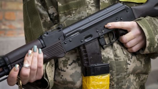 Príslušníčka civilnej obrany na Ukrajine so zbraňou v ruke.