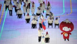 lyžiar Miroslav Haraus a curlerka Monika Kunkelová so slovenskou vlajkou počas otváracieho ceremoniálu XIII. zimných paralympijských hier na Národnom štadióne v Pekingu.