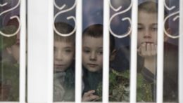 Chlapci pozerajú von cez okno detského domova v ukrajinskom Charcyzku.