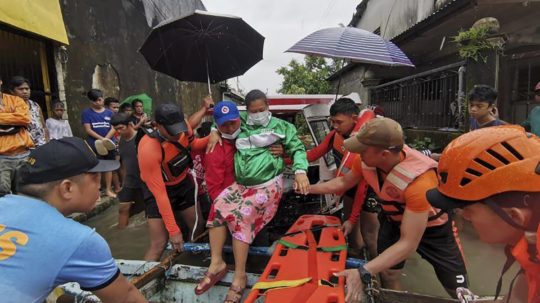 Záchranári pomáhajú evakuovať obyvateľov v zaplavenej dedine Abuyog, provincie Leyte v centrálnych Filipínach.