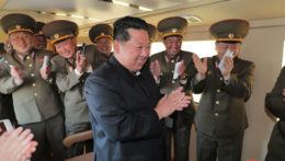Severokórejský líder Kim Čong-un obklopený uniformovanými úradníkmi.