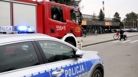 Policajné auto a hasičské auto pred uhoľnou baňou Pniówek v poľskej obci Pawlowice 20. apríla 2022.