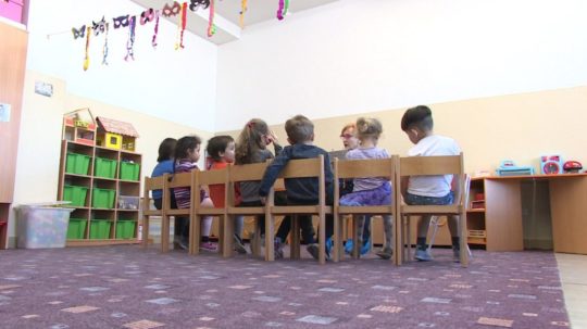 Na snímke deti sediace za stolom v škôlke.