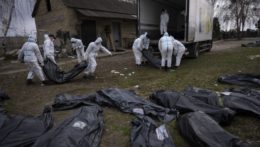 Dobrovoľníci nakladajú telá mŕtvych civilistov z Buče do nákladného auta.