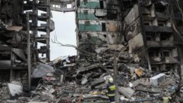 Príslušníci záchranných zložiek prehľadávajú trosky niekoľkoposchodového obytného domu zničeného po ruskom útoku.