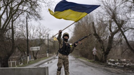 Na snímke vojak drží ukrajinskú vlajku.